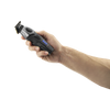 A hand holding a black and gray cordless electric trimmer with blue LED indicator lights, shown against a solid white background.