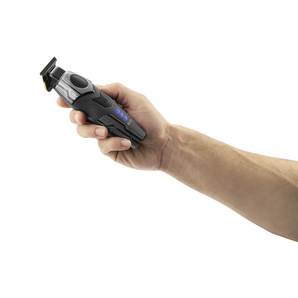 A hand holding a black and gray cordless electric trimmer with blue LED indicator lights, shown against a solid white background.