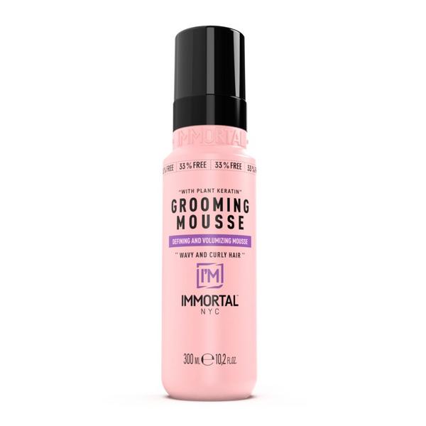 Pink bottle of Immortal NYC Grooming Mousse on a white background