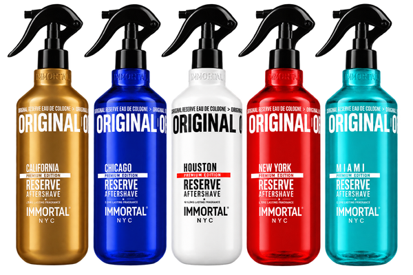 Five spray bottles of Immortal Reserve Eau de Cologne aftershaves in different colors: gold, blue, white, red, and teal, arranged side by side on a white background.