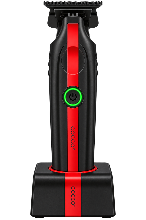A black cordless hair clipper with a vertical red accent stripe and a glowing green power button, shown standing on its matching black charging base against a plain white background. The brand name 'cocoo' is printed vertically on both the clipper and the base.