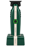 A Cocco electric trimmer in dark green and cream, standing upright on its matching charging dock against a solid white background.