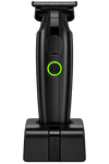 Black electric shaver with a green illuminated power button, shown upright on its matching charging dock against a solid white background.