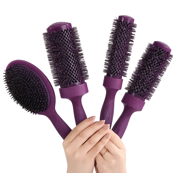 Four purple hair styling brushes with dark bristles, held together by a person's hands against a solid white background.