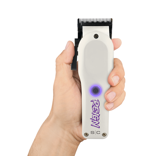 Hand holding a white hair clipper with purple branding on a white background