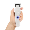 Hand holding a white grooming tool with 'Saber' branding on a white background