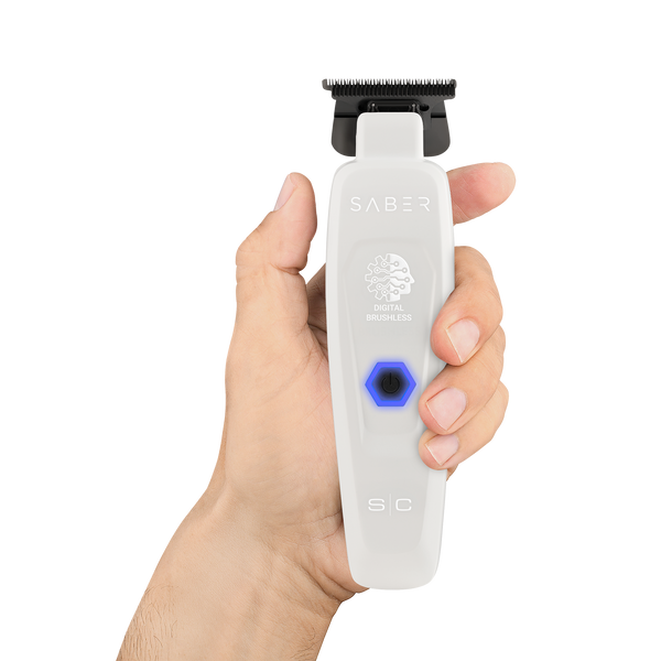 Hand holding a white grooming tool with 'Saber' branding on a white background